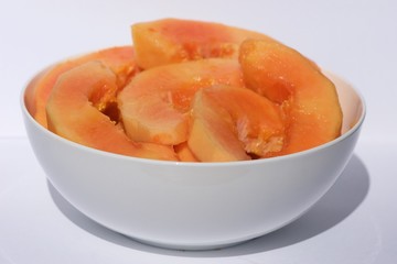 African papaya into pieces in white bowl