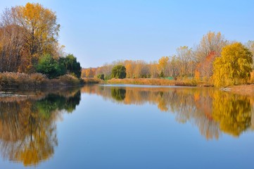 Water Reflected Autumn Colors With Blue Sky