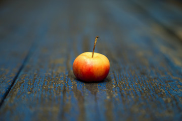 Apple, natural non-GMO, without chemistry, with a child's hand, on a wooden old background