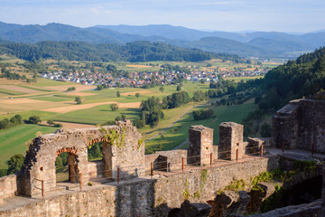 Fototapeta na wymiar Beautiful landscape of dilapidated castle ruin against small village in Germany in the evening