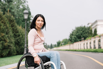 Fototapeta na wymiar young disabled woman in wheelchair smiling and looking at camera