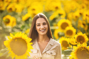 Beautiful young woman posing in sunflower field