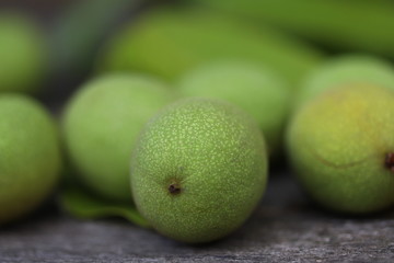Walnuts plucked from a tree in a green shell. Harvest of walnuts. Selective focus. Macro.