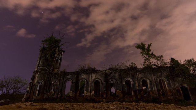 Timelapse Exterior of abandoned Church of the Sacred Heart of Jesus at night with cloud and star at Pagar Tras, Sungai Lembu, Southeast Asia.