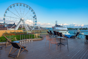 Hlsinki. Finland. Harbor for tourists. Ferris Wheel in Helsinki. Motor ship at the pier. Street...