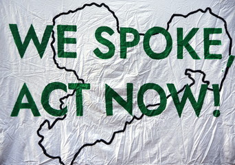 Slogan auf einem Transparent: "We spoke act now!"