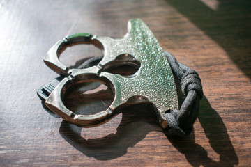 Metal brass knuckles on a wooden background.