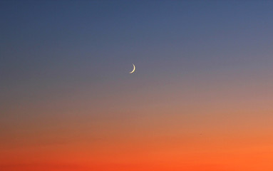Red sunset with crescent moon in Brighton