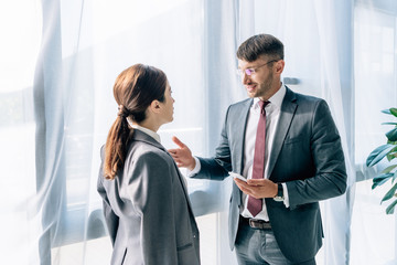 journalist talking with businessman in formal wear and glasses