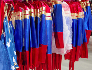 A clothes rack full with a collection of colorful holiday parade costumes