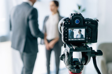 selective focus of digital camera shooting journalist and businessman