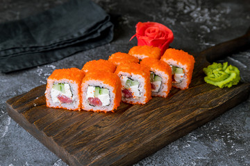 California roll with tuna on the board on grey concrete table