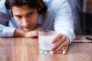 Sick male employee suffering in the office