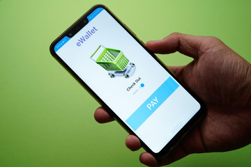 A mobile app eWallet conceptual with mock up apps and men hand holding phone