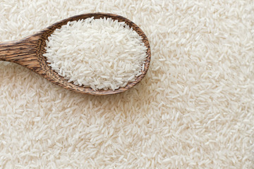 Top view of Wooden ladle on many rice texture background