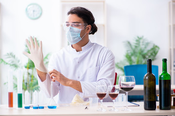 Male chemist examining wine samples at lab