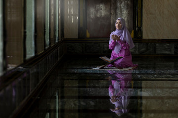 Muslim women wearing purple shirts Doing prayer According to the principles of Islam..