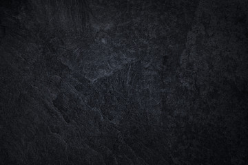 Dark grey black slate background or natural black stone texture.