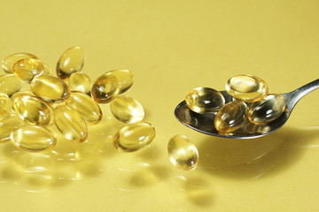 fish oil capsules isolated on yellow background