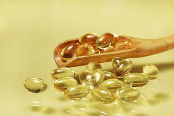 fish oil capsules isolated on yellow background