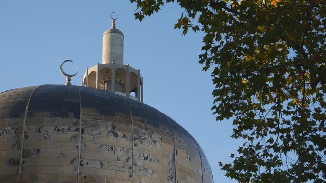 A close up view of a mosque dome and minaret in autumn.