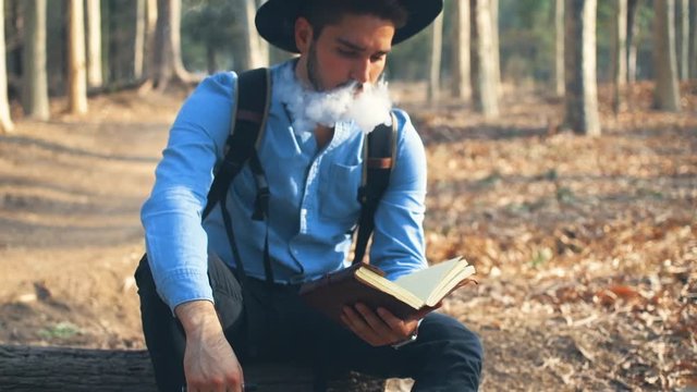 Explorer vaping and reading in the woods