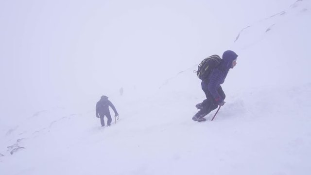 Slow Motion View Of Mountain Climbers On Winter Ascent Using Ice Axe.