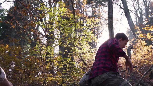 Two Hikers Throwing Leaves At Each Other Whilst Trekking Through The Woods. Slow Motion