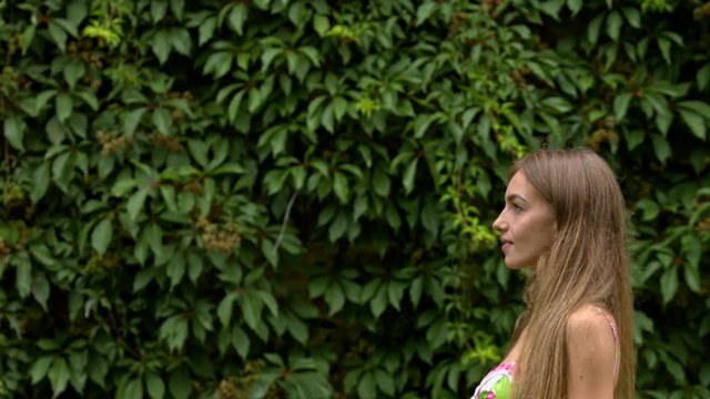 Side shot of a brunette young woman which is making some soapbubbles in the nature.