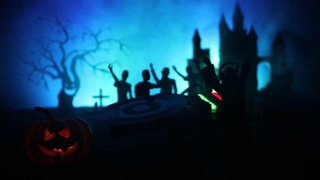 Happy Halloween horror party concept. Scary view of dancing zombies at cemetery with Dj and club lights. Creative artwork decoration. Useful as a party poster or greeting card. Selective focus