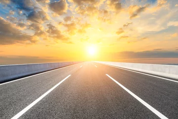 Schilderijen op glas Straight asphalt highway road and beautiful sunset clouds © ABCDstock