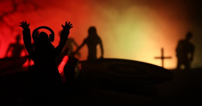 Happy Halloween horror party concept. Scary view of dancing zombies at cemetery with Dj and club lights. Creative artwork decoration. Useful as a party poster or greeting card. Selective focus