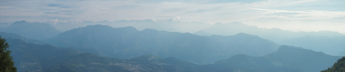 Morning landscape on hills and mountains with humidity in the air and pollution. Panorama from Linzone Mountain, Bergamo, Italy