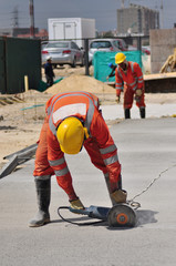 Construction worker operated Circular saw with a diamond blade for cutting asphalt and concrete 