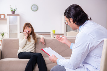 Young female patient discussing with male psychologist personal