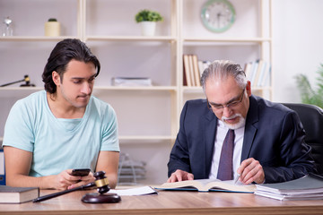 Young man visiting experienced male lawyer