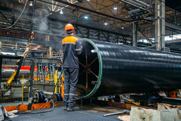 Worker installs clamping ring on coated pipe