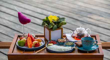 Healthy breakfast consisting of omelette, fruits, tea, variety of juice