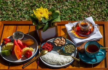Healthy breakfast consisting of omelette, fruits, tea, variety of juice