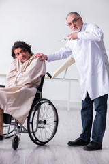 Old male doctor psychiatrist and patient in wheel-chair