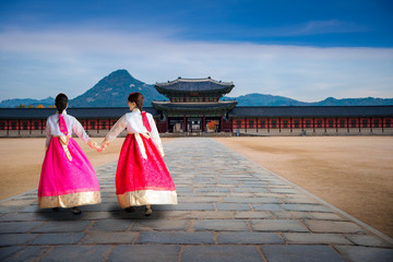 Asian girl in korean dress walking infront of gate of  gyeongbokgung palace