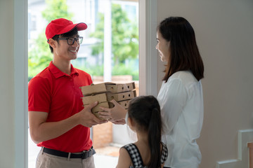 Asian woman recieve pizza box from pizza boy at the home