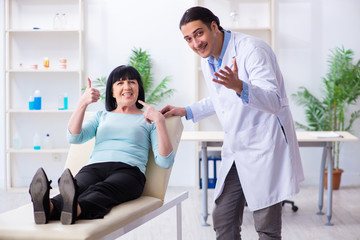 Old woman visiting young doctor dentist