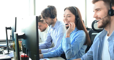 Attractive positive young businesspeople and colleagues in a call center office.