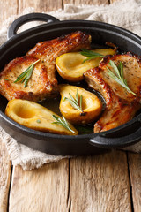 Autumn food pork chops with ribs baked with pears and rosemary in honey sauce in a pan close-up. vertical