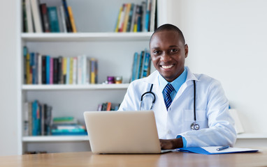 African american general practitioner working at computer