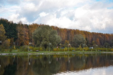 autumn landscape with lake and trees and clouds in sky