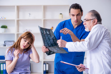 Fototapeta premium Two doctors examining young woman