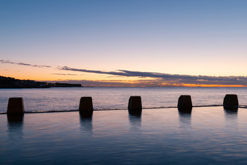 The rock at the edge of Coogee rock pool with dawn sky.