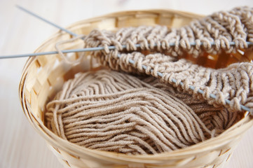 beige yarn for knitting in a straw basket